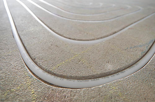 Blick auf eine frisch montierte Fußbodenheizung von AMG Heizsysteme, hier das Beispiel eines Fräs-Systems.