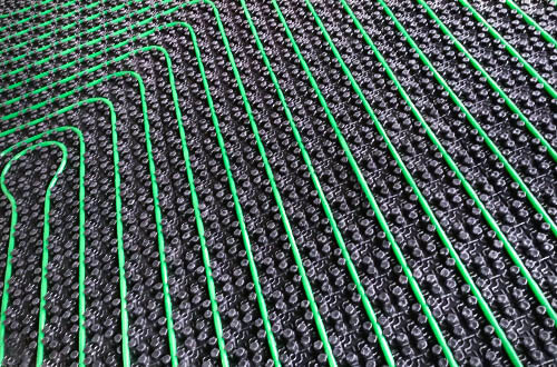 Blick auf eine frisch montierte Fußbodenheizung von AMG Heizsysteme, hier das Beispiel eines Noppenplatten-Systems.
