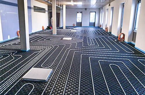 Blick auf eine frisch montierte Fußbodenheizung von AMG Heizsysteme, hier das Beispiel eines Noppenplatten-Systems.