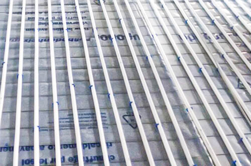 Blick auf eine frisch montierte Fußbodenheizung von AMG Heizsysteme, hier das Beispiel eines Trägermatten-Systems.